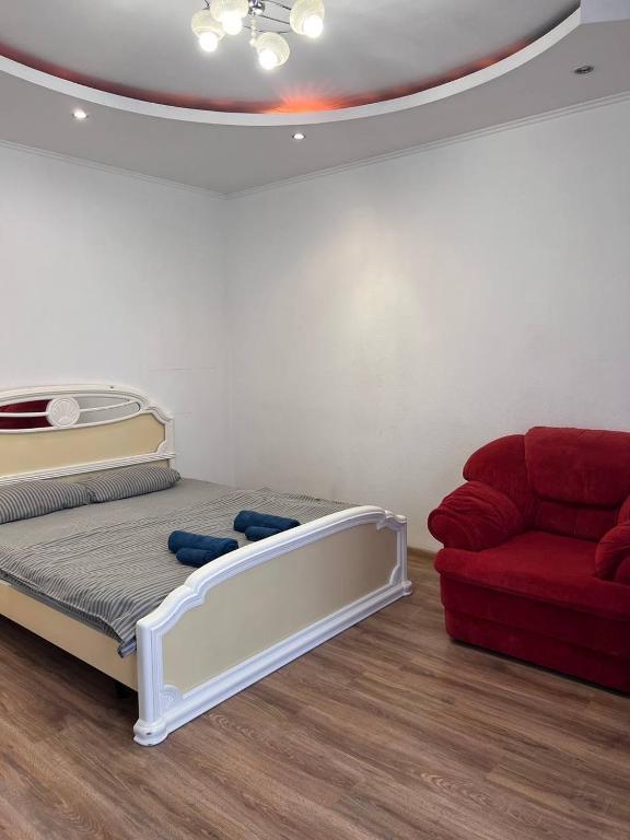 a bed in a room with a red couch at Студія Люкс з терасою в центрі міста in Kryvyi Rih
