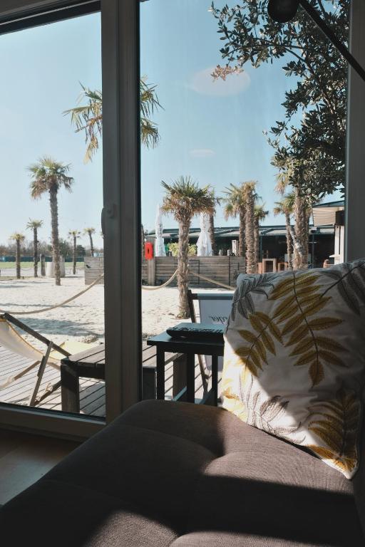a living room with a view of a patio with palm trees at Pannolio Beach Boutique Apartment in Eisenstadt