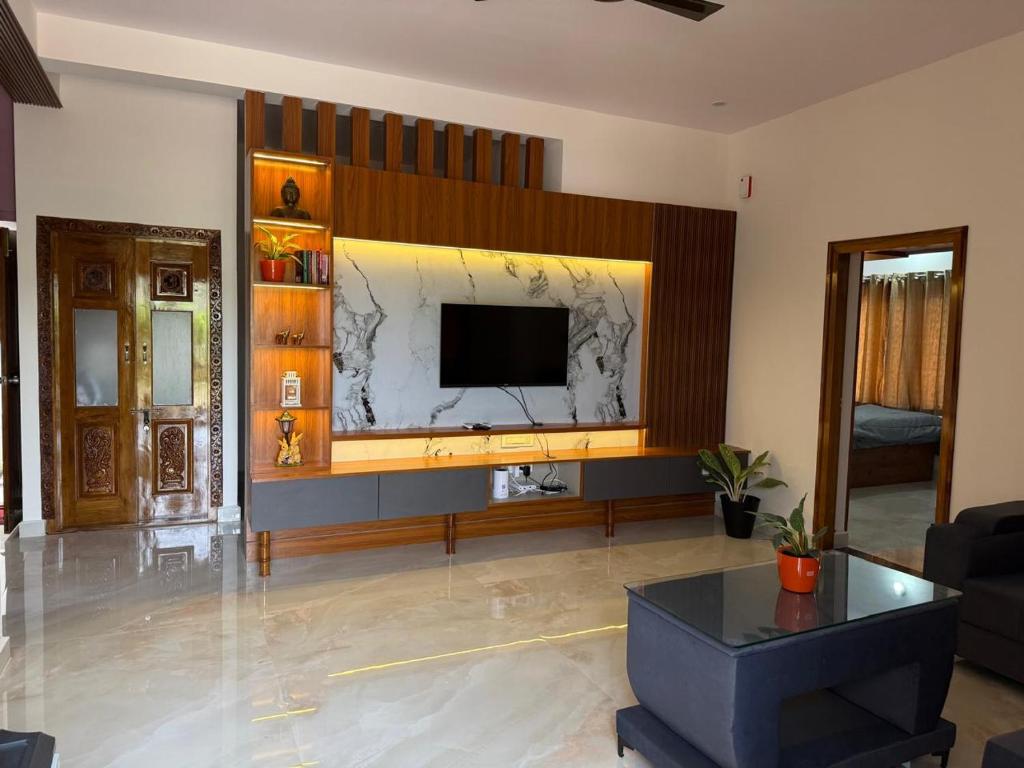 ein Wohnzimmer mit einem Flachbildfernseher an der Wand in der Unterkunft Hill View Comforts in Mysore