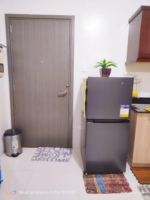 a refrigerator in a kitchen with a door at Sugarland Urban Nook in Bacolod