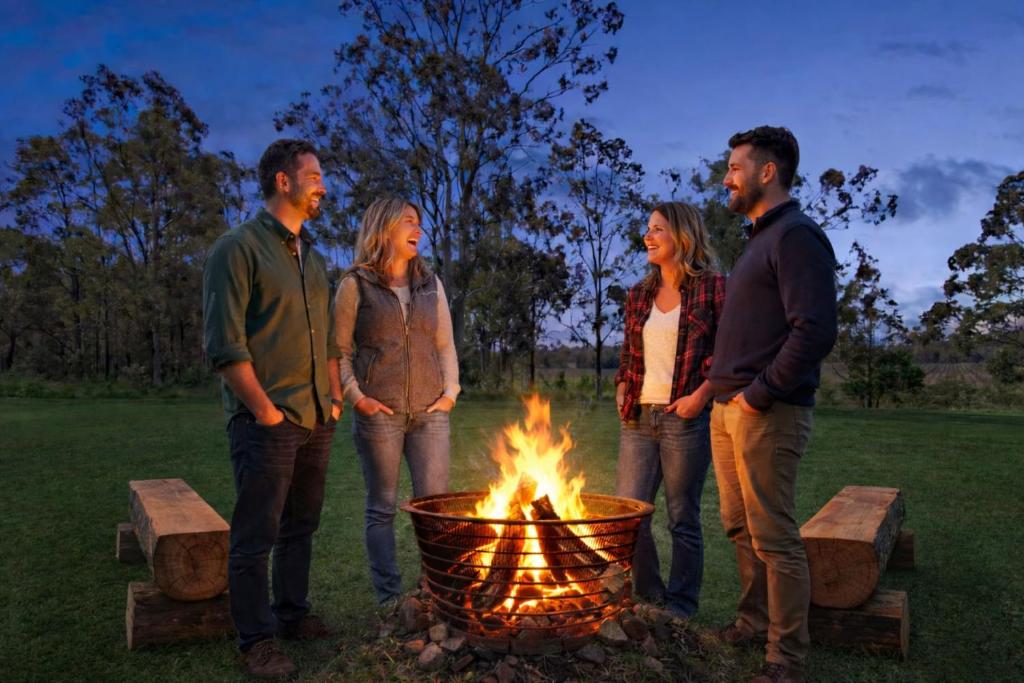 a group of people standing around a fire at Glandore Estate in Pokolbin
