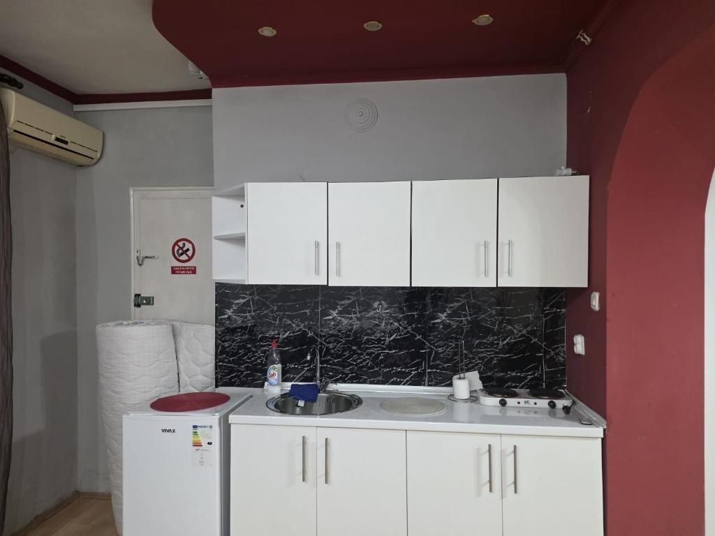 a kitchen with white cabinets and a sink at MBM Apartman in Bitola