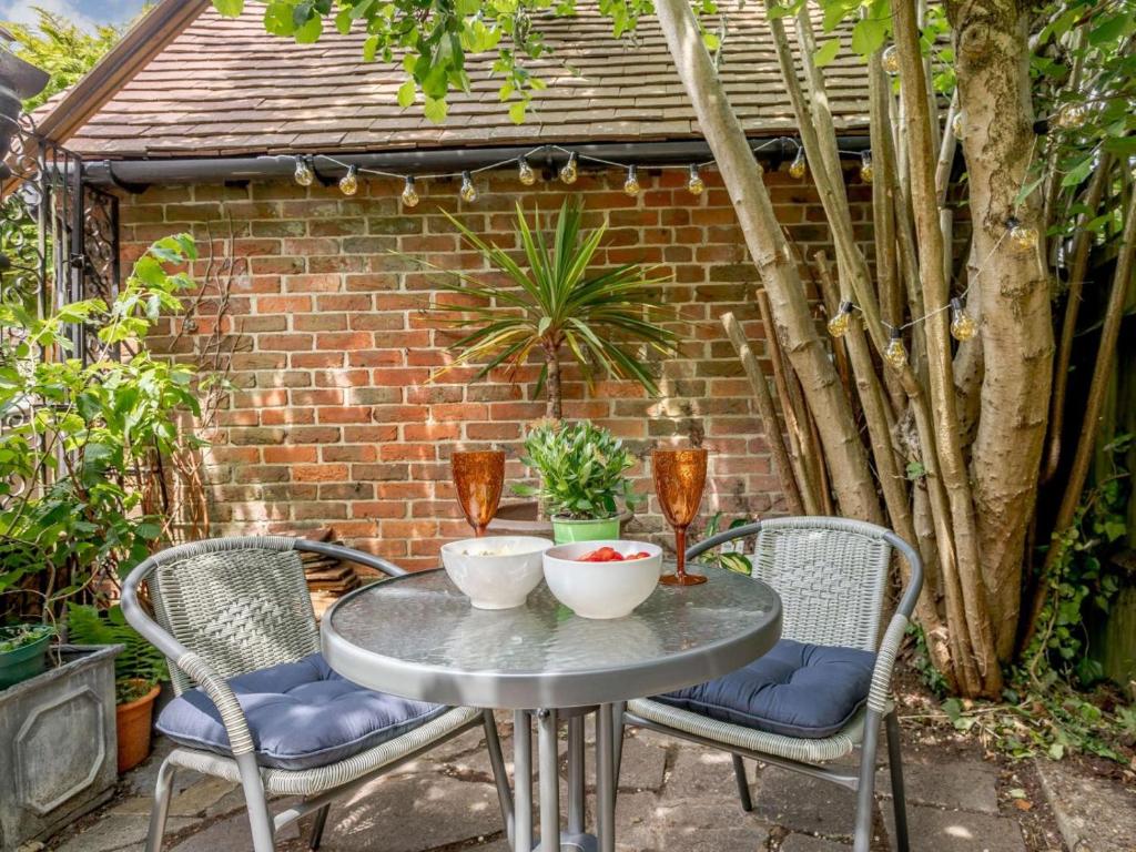 a patio table with two chairs and a brick wall at 2 Bed in Westerham oc-88626 in Westerham
