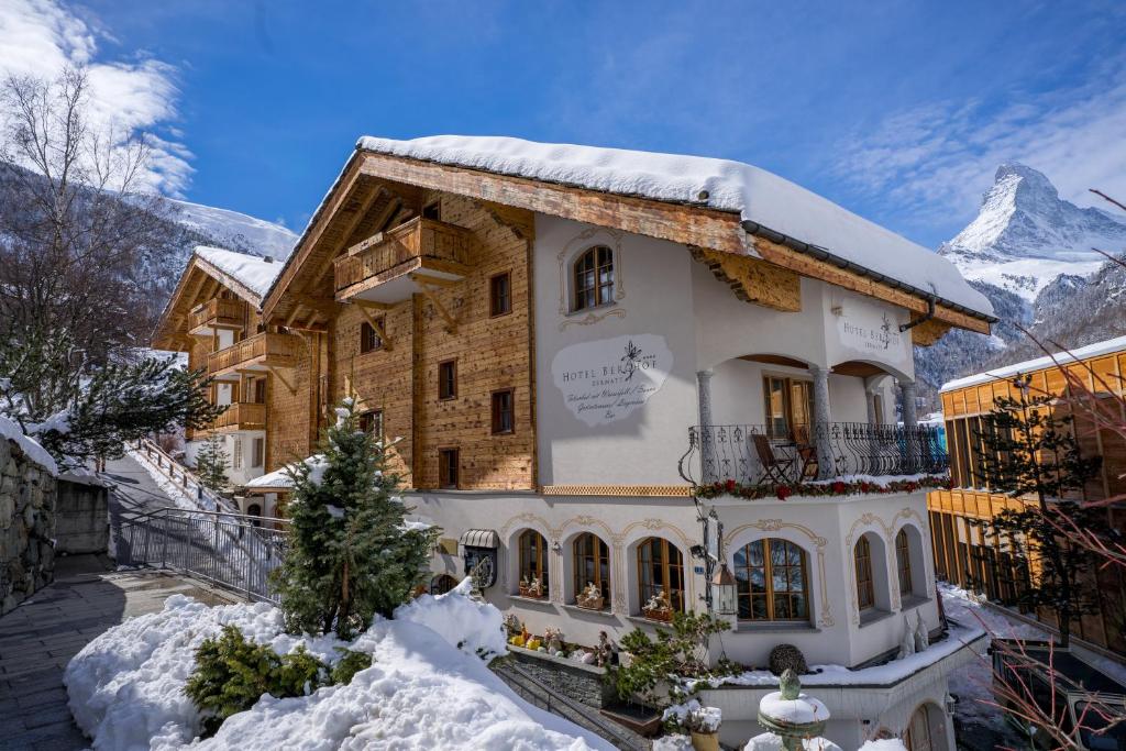 a house in the mountains with snow on the ground at Hotel Berghof in Zermatt