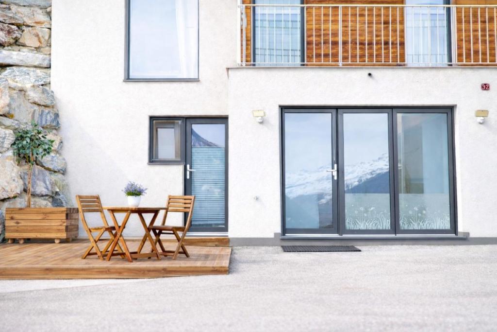 a patio with a table and chairs and a building at Maison D'Hortense chalet le Chamois in Hérémence