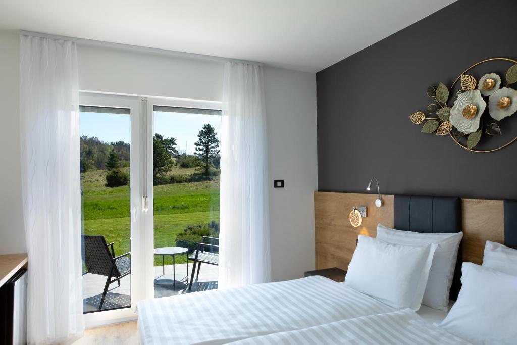 a bedroom with a bed and a sliding glass door at Rooms Gašper 1 in Postojna