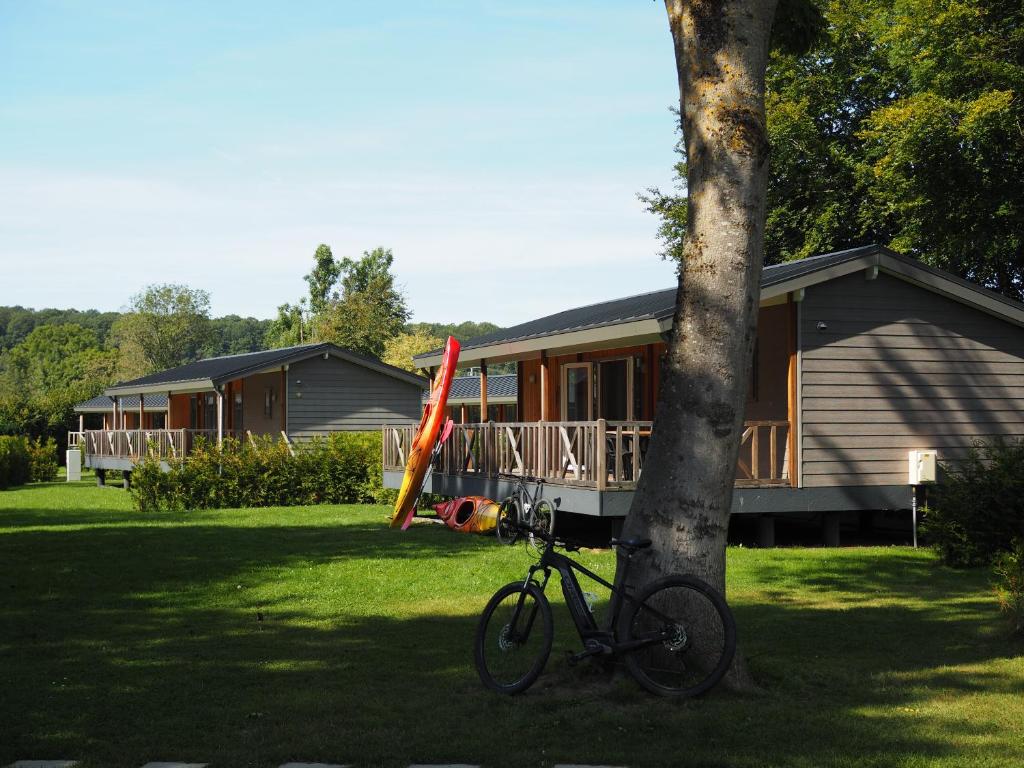 a bike parked next to a tree in front of a house at Moulin de Hotton in Hotton