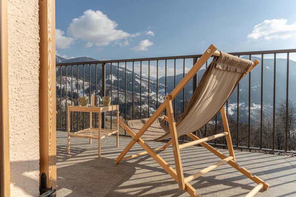 a wooden chair sitting on a balcony with a table at Nest Love, Bedollo Ospitar in Bedollo
