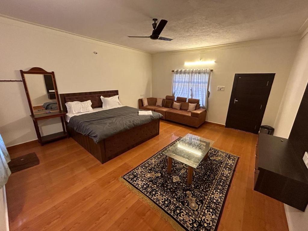 a living room with a bed and a couch at Aroha Farm Stay in Yelagiri