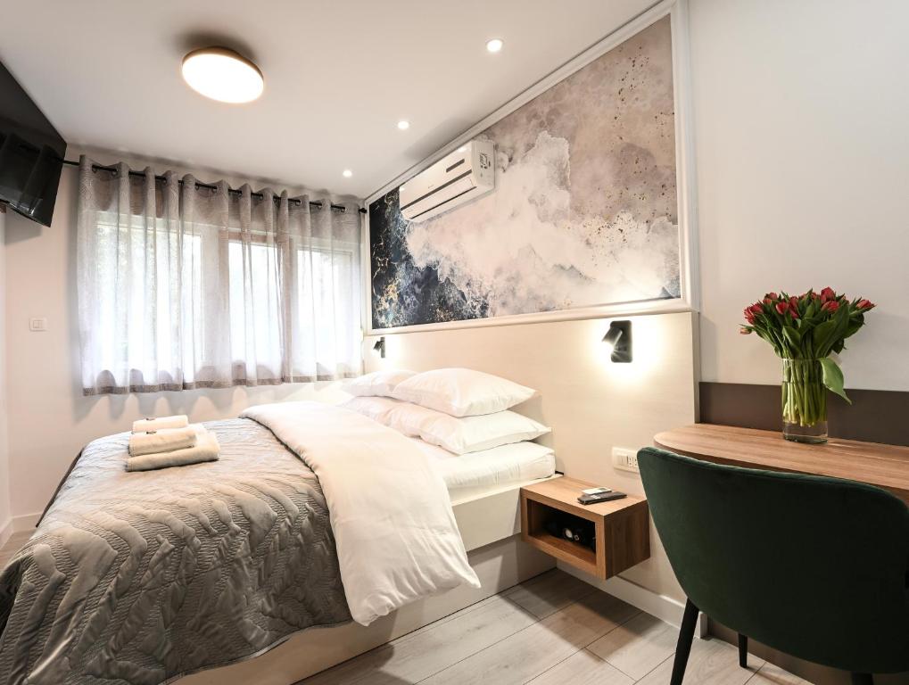 een slaapkamer met een bed en een bureau bij Laurea Rooms in Split