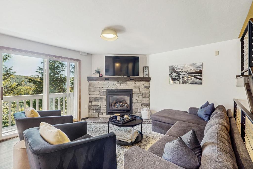 a living room with a couch and a fireplace at Apres Escape in Sandpoint