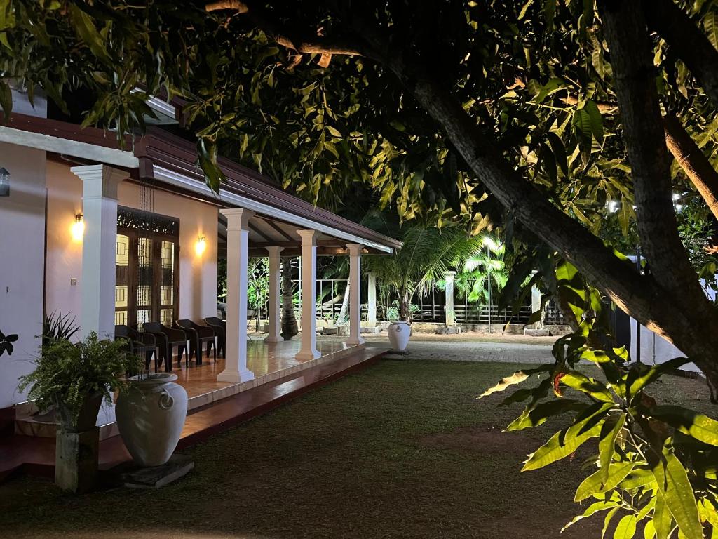 a porch of a building with chairs and trees at Villa 87 in Katunayaka