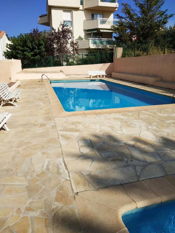 a swimming pool in front of a building at Monplaisir in Fréjus