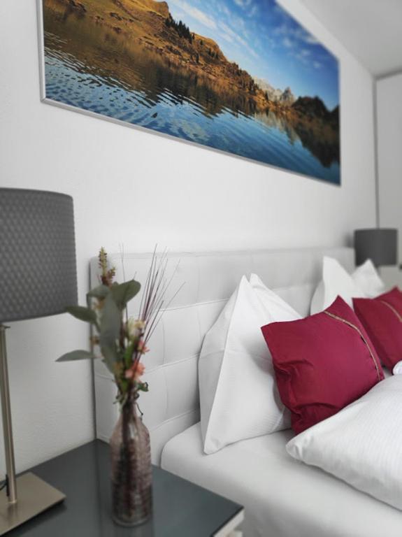 a living room with a white couch with red pillows at Central Serviced Apartment in Engelberg