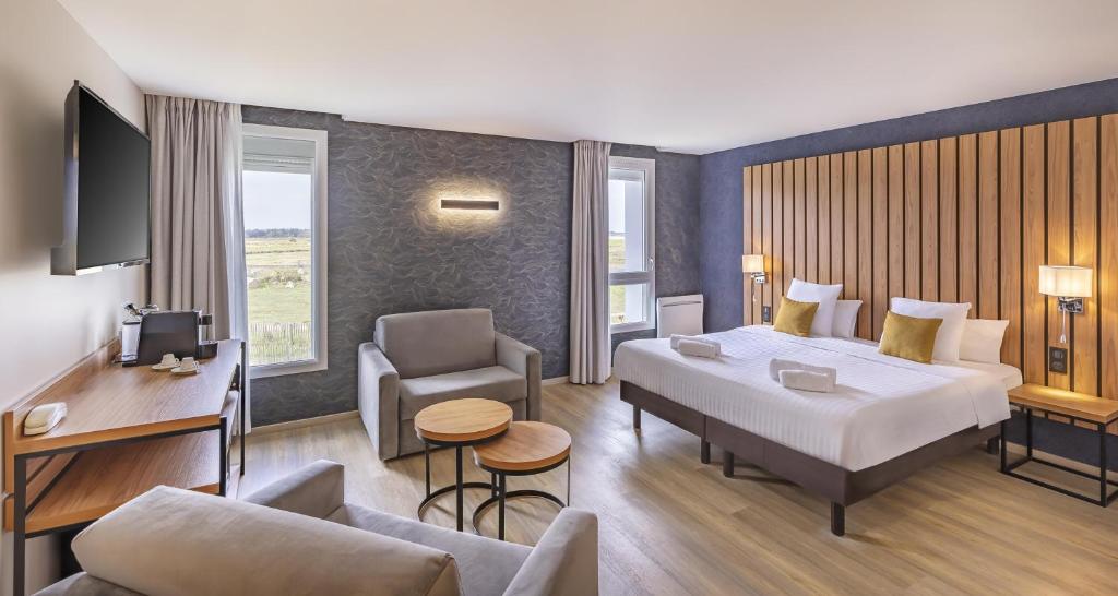 une chambre d'hôtel avec un grand lit et un bureau dans l'établissement Best Western Côte des Sables Plouescat, à Plouescat