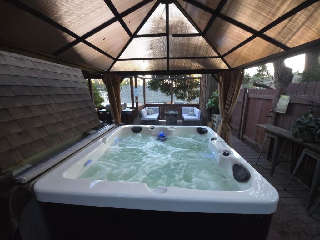 a jacuzzi tub in a backyard with a roof at Hot Tub A-Frame Cabin Lake Arrowhead Escape in Rimforest
