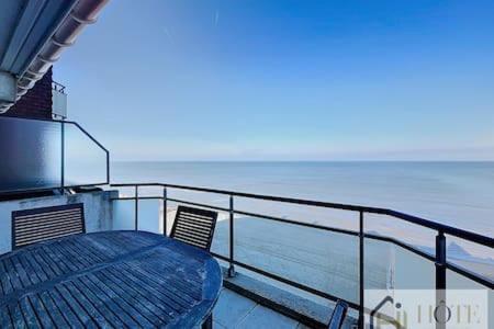 a table and chairs on a balcony with the ocean at Le Panoramique Marin- 2Ch in Bray-Dunes