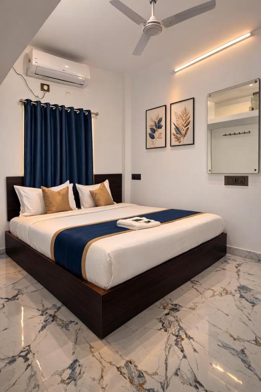 a bedroom with a large bed with blue curtains at Hotel Rhythms Residency in Chennai