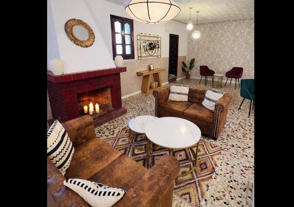 a living room with couches and a fireplace at AIRE Vejer - recién reformado 2026 in Vejer de la Frontera