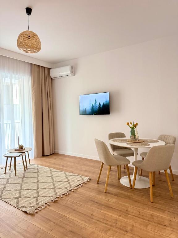 a white living room with a table and chairs at Forestis Thermalis in Baile Felix
