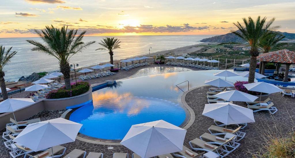 a pool with chairs and umbrellas at a resort at Pueblo Bonito Sunset Beach Owners Exec Suite 1BR2B REQUEST DATE see Clay & Lisa in Cabo San Lucas