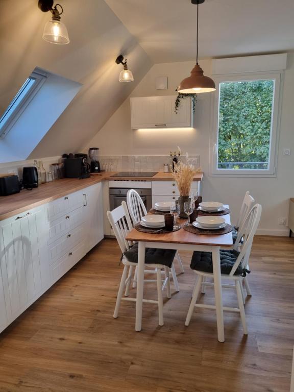 a kitchen with a table and chairs in a kitchen at Le perchoir de Pibri - Les apparts de Maddy in Meyssac