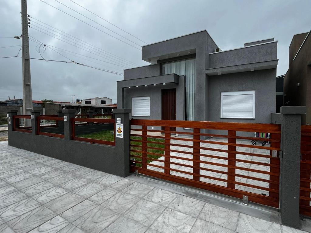 a small house with a fence and a gate at Refúgio Rossa in Xangri-lá