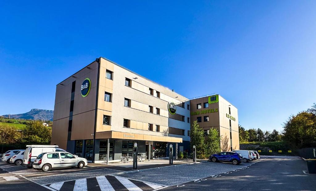 a building with cars parked in a parking lot at B&B HOTEL Aix-les-Bains in Grésy-sur-Aix
