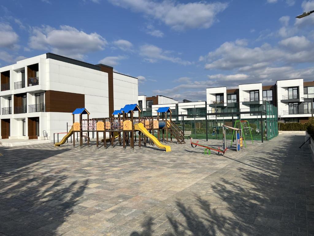 a playground with a slide and play equipment in front of a building at Cruds Arena Chisinau in Chişinău