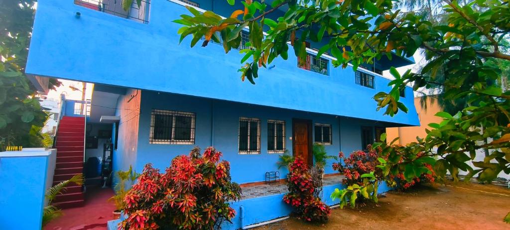 a blue house with flowers in front of it at Aadhya guest house in Tiruvannāmalai