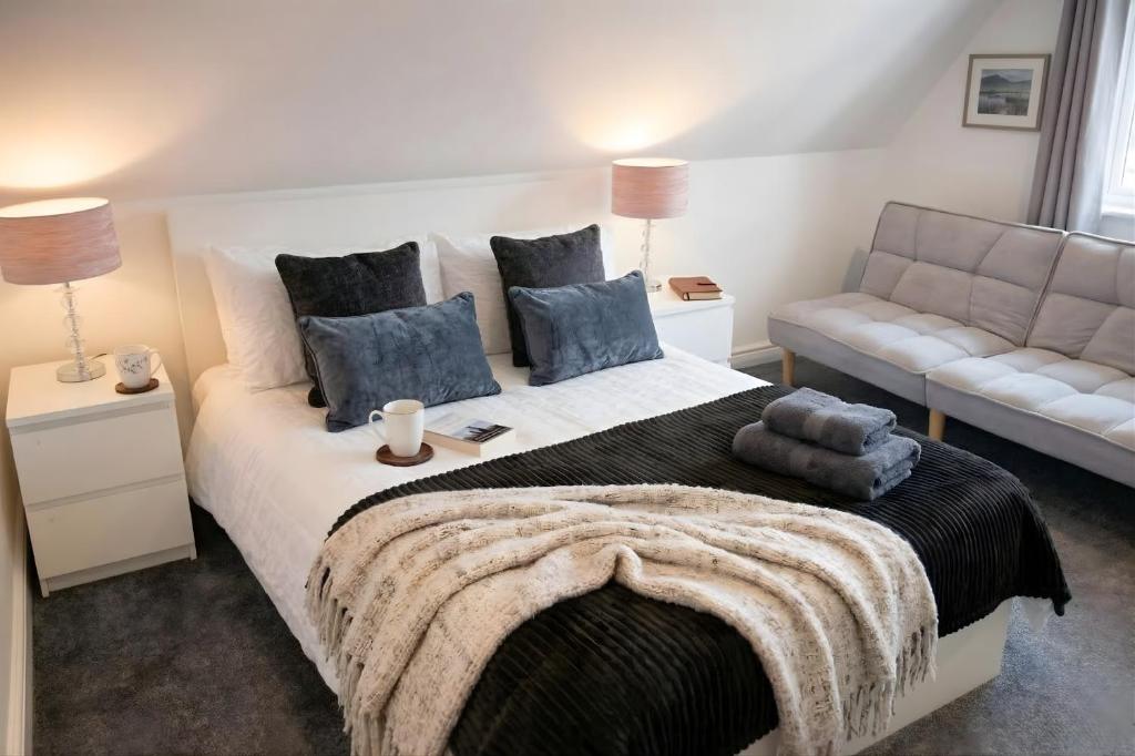a bedroom with a large bed and a couch at Rosey Lodge -1Bedroom Cousy Flat - Parking, Netflix, WIFI - Close to Blenheim Palace & Oxford - F5 in Oxford