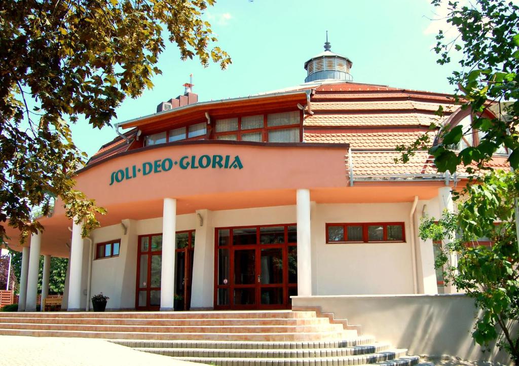 a building with stairs in front of it at SDG Családi Hotel és Konferencia Központ in Balatonszárszó