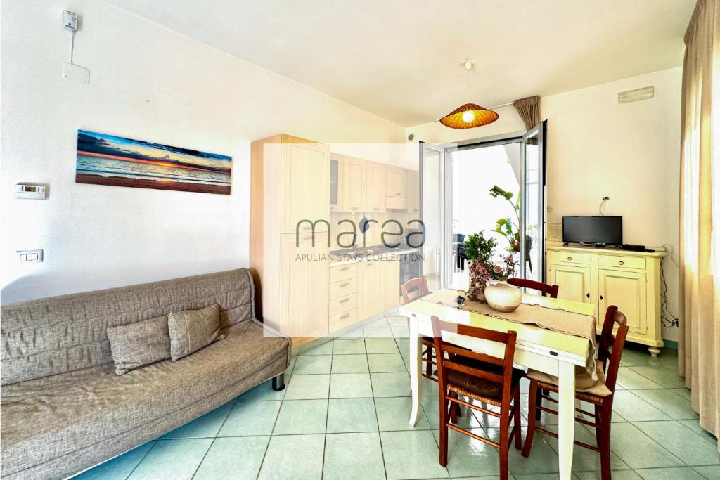 a living room with a couch and a table at Casa Appia - Authentic Beachfront House with Sea- View Garden in Santa Maria al Bagno - Marea Stays Collection in Nardò