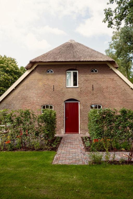 a red brick house with a red door at Boerderij de Voorste Eng in Otterlo