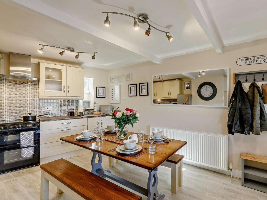 a kitchen with a wooden table with flowers on it at 3 Bed in Holmfirth oc-91797 in Holmfirth