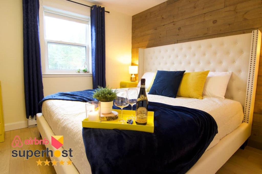 a bedroom with a bed and a table with a bottle of wine at Lakeside Getaway #5 Spa Sauna Firepit in Sainte Brigitte de Laval