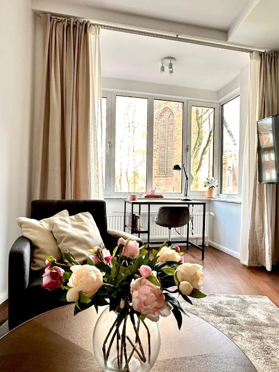 a living room with a vase of flowers on a table at Der Stader Turmblick in Stade