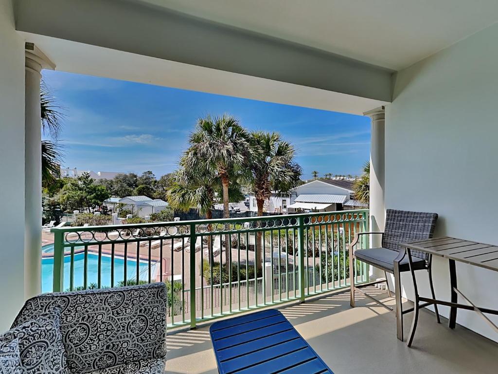 a balcony with a table and chairs and a view of a pool at Inn at Seacrest #203 - 30A Get-A-Way in Rosemary Beach