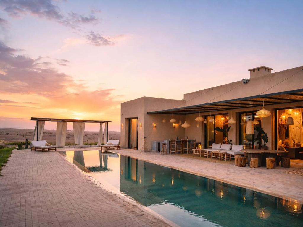 a villa with a swimming pool at sunset at Palais Victoria in El Aïn