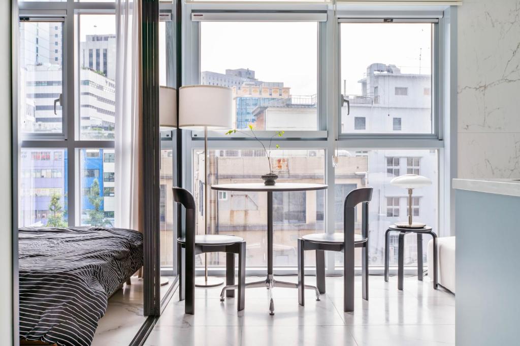 a bedroom with a table and chairs in front of a window at Balance Seoul Stay in Seoul