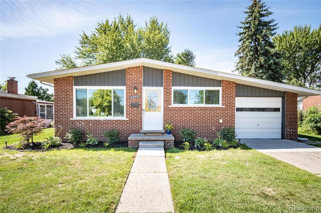 a brick house with a garage at Lonnie in Westland