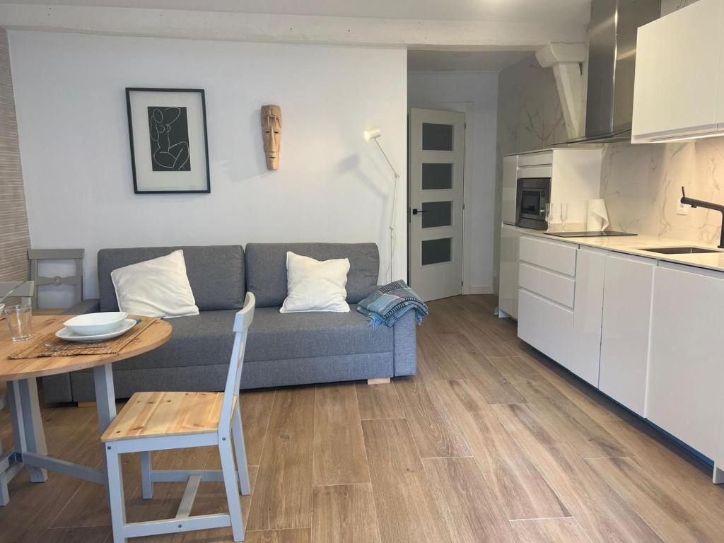 a living room with a couch and a table and a kitchen at ALAIA Mundaka in Mundaka