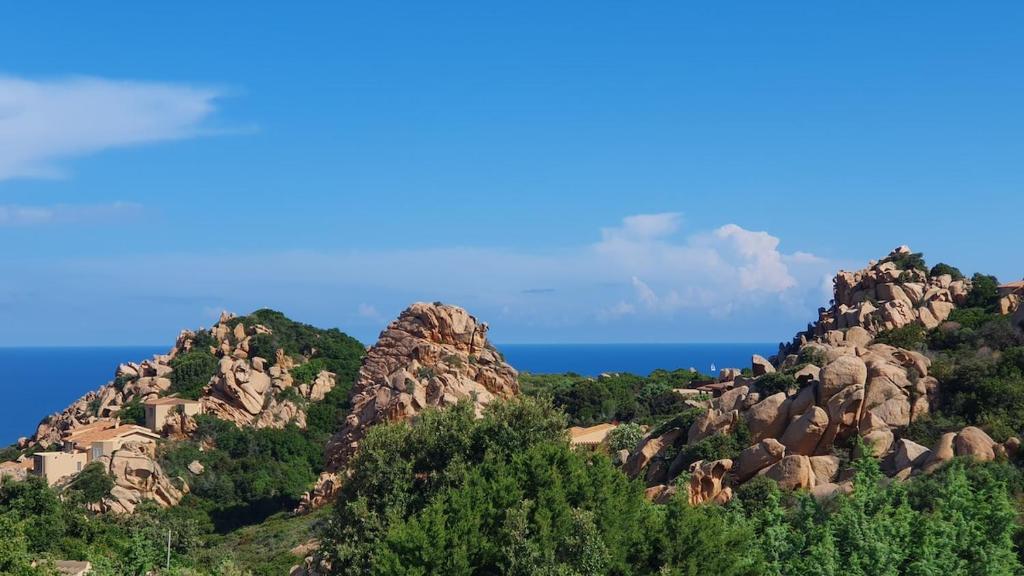 a mountain with rocks and the ocean in the background at Poolvilla Bellavista - Vista Panoramica sul Mare in Costa Paradiso