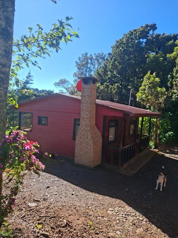 a red house with a chimney on top of it at Las Bromelias Lodge in Paso Macho