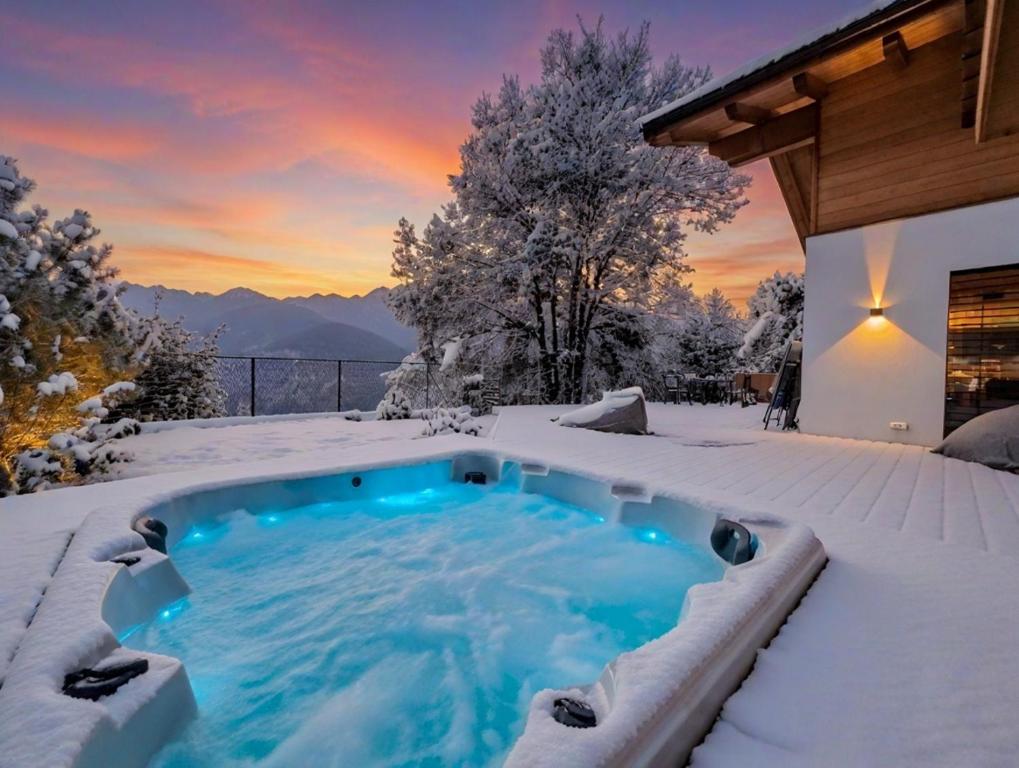 a hot tub in the snow in a backyard at Chalet Astra, Whirlpool & Sauna in San Pancrazio dʼUltimo