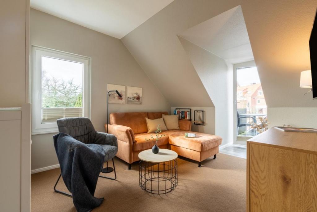 a living room with a couch and a chair at Pier17 Appartement 3 in Borkum