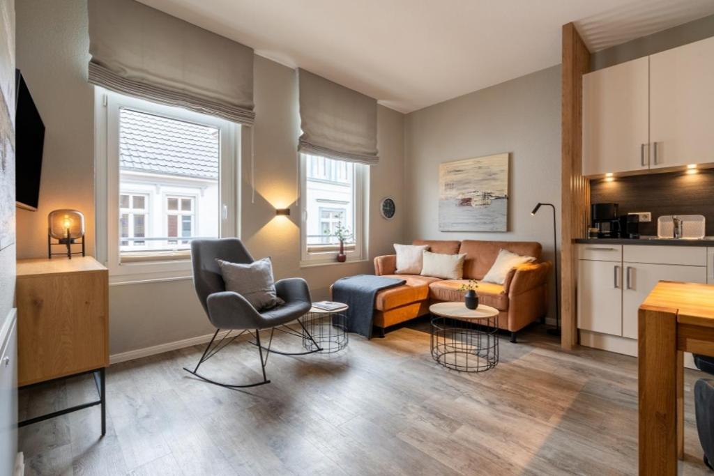 a living room with a couch and a chair at Pier17 Appartement 4 in Borkum