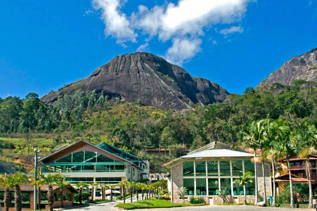 a mountain in the distance with a building and a building at Hotel Vila Verde in Nova Friburgo