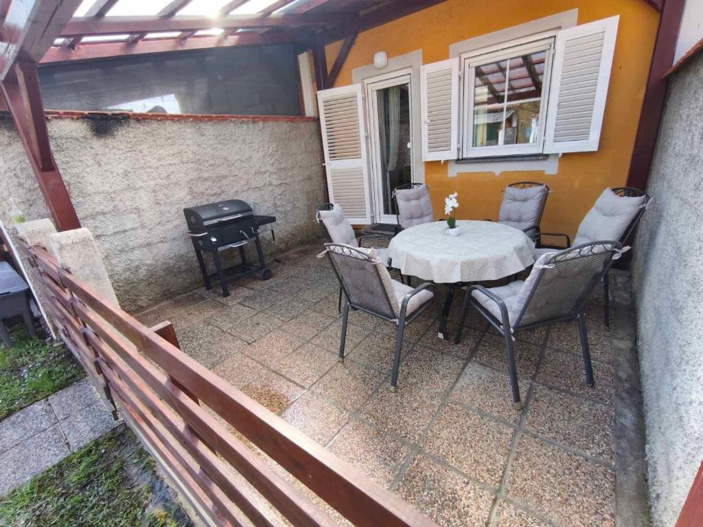 a patio with a table and chairs and a grill at Apartment by MICHELLE - Terme Čatež House in Čatež ob Savi