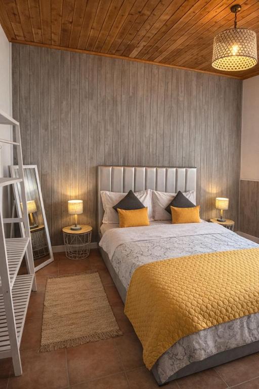 a bedroom with a large bed with yellow pillows at Cantinho do Sol in Mosteiros